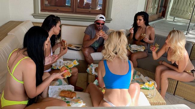 Travers 'The Candyman' Beynon with his wife Taesha (in white, left) and his four girlfriends Amber (yellow), Gabi (blue), Vanesa (black with blond hair) and Nisha at the Candy Shop Mansion. Picture: Clare Stramkowski