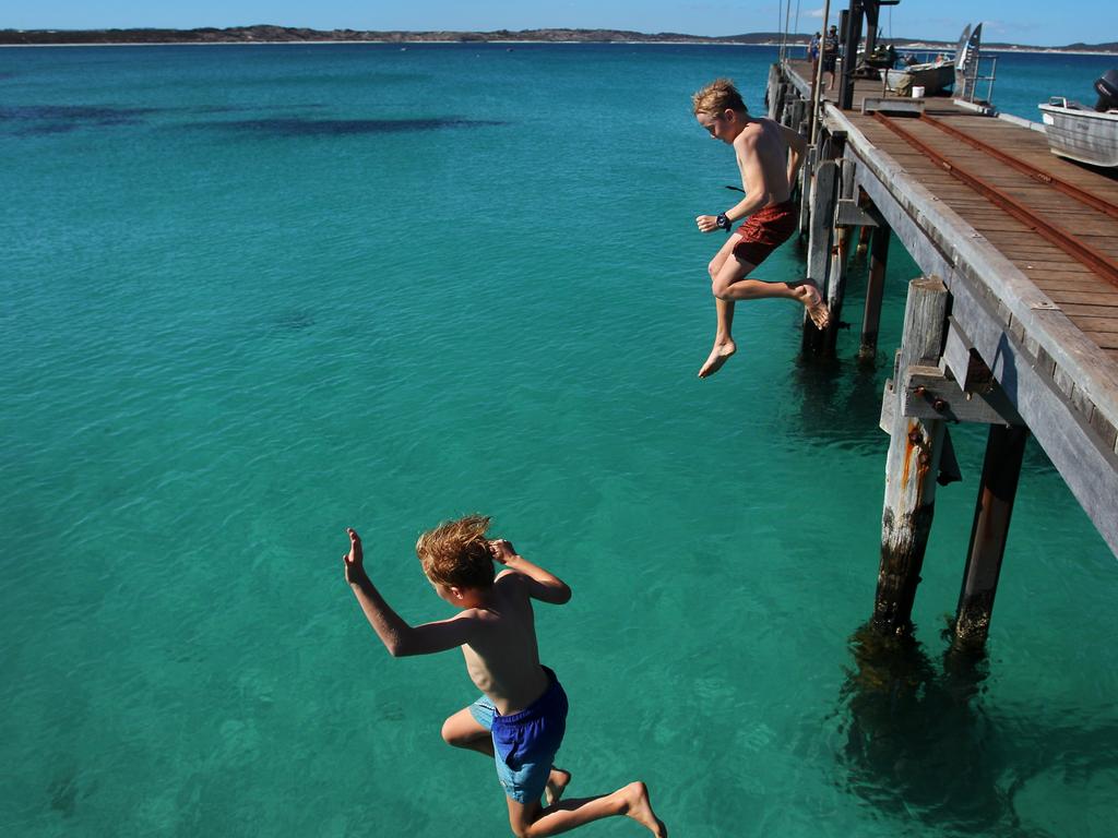 KANGAROO ISLAND, AUSTRALIA - FEBRUARY 25: Young boys jump off Vivonne Bay Jetty into the water on February 25, 2020 in Kangaroo Island, Australia. Over a third of Kangaroo Island, including much of the Flinders Chase National Park, was burnt during the recent bushfires that started on 4 January. Two people lost their lives, while tens of thousands of native animals and farming livestock were also killed. The Wildlife, Ecosystems and Habitat Bushfire Recovery Taskforce estimates as many as 90 percent of Kangaroo Island's famous koala population perished in the recent bushfires, with only 5,000 to 10,000 koalas remaining in the area from an original population of about 60,000. Kangaroo Island's economy is reliant on agriculture and tourism Ã¢â¬â worth an estimated 180 million dollars Ã¢â¬â and focus is now turning to reviving the industries post the bushfires. The South Australian Tourism Commission launched the #BookThemOut campaign to encourage tourists to visit the bushfire affected areas in the Adelaide Hills and Kangaroo Island, with the recent Kangaroo Cup Racing Carnival reaching record attendance this past weekend. However, with the Island known to be a popular tourism destination for Chinese tourists the local industry is now also being heavily affected by coronavirus.The Federal Government has announced a royal commission into this summer's devastating bushfires across Australia, with a specific focus on preparedness for future bushfire seasons. Former Australian Defence Force (ADF) chief Mark Binskin, former Federal Court judge Annabelle Bennett and leading environmental lawyer Andrew Macintosh are due to deliver their findings by the end of August. (Photo by Lisa Maree Williams/Getty Images)