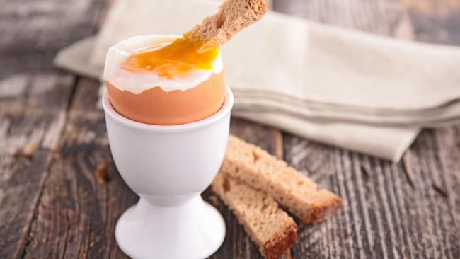 Soft boiled egg being served with slices of bread