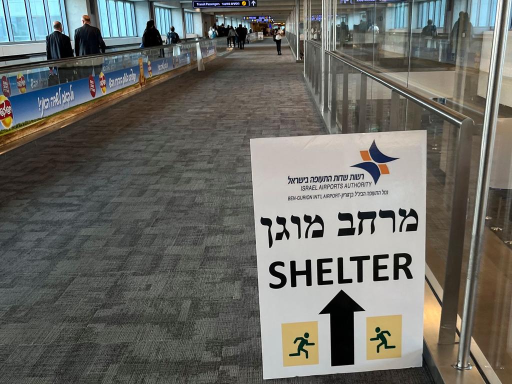 A sign informing passengers about the location of rocket shelters is set-up in a hallway as travellers arrive at Ben Gurion International Airport near Tel Aviv. Picture: AFP