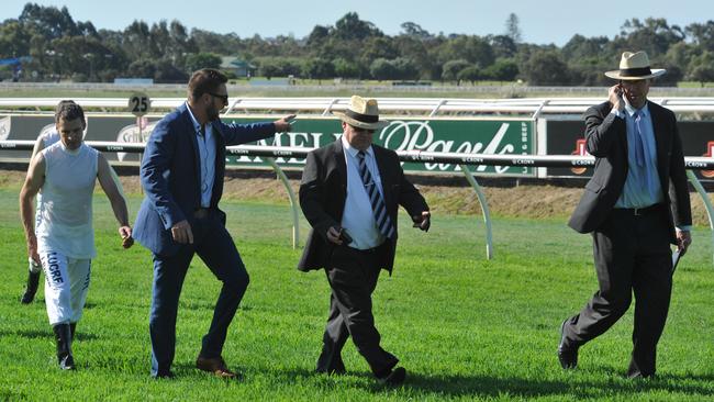 chief steward Brad Lewis (right) inspects the Ascot track with jockeys, trainers and Stewards about 80m from the finish line where two horses Lenience and Watermans Bay were participating in a training gallop between races 4 and 5. About 80m before the line Lenience ridden by Steven Parnham slipped and fell where Steven was dislodged. After the mishap stewarts in consultation with trainers and jockeys decided to postpone the final 4 events.