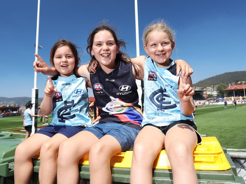 Sisters Phoebe, 5, left, Millie, 9, and Sophie Maher, 7, all of Melbourne, at the AFLW match between North Melbourne and Carlton at North Hobart Oval. Picture: LUKE BOWDEN