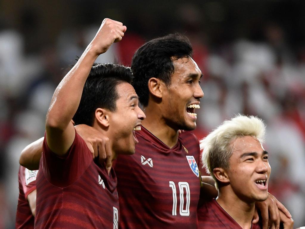 Thailand's midfielder Thitiphan Puangjan (L) celebrates his goal with teammates Thailand's forward Teerasil Dangda, amd Thailand's midfielder Chanathip Songkrasin (R) during the 2019 AFC Asian Cup group A football match between the United Arab Emirates and Thailand at the Hazza bin Zayed Stadium in Al-Ain on January 14, 2019. (Photo by Khaled DESOUKI / AFP)