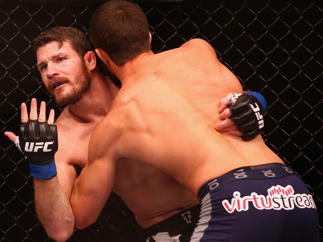 Michael Bisping appeals to the referee after being cut above the eye by Luke Rockhold.