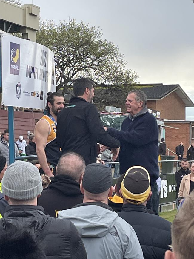 Michael Goonan presents the premiership trophy.