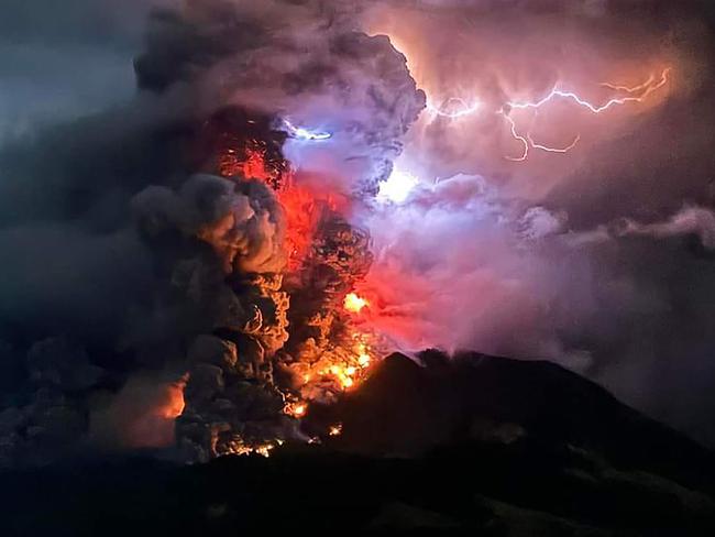 This handout photograph taken and released by the Center for Volcanology and Geological Hazard Mitigation on April 17, 2024 shows Mount Ruang spewing hot lava and smoke as seen from Sitaro, North Sulawesi. A volcano erupted several times in Indonesia's outermost region overnight on April 17, forcing hundreds of people to be evacuated after it spewed lava and a column of smoke more than a mile into the sky. (Photo by Center for Volcanology and Geological Hazard Mitigation / AFP) / RESTRICTED TO EDITORIAL USE - MANDATORY CREDIT AFP PHOTO / CENTER FOR VOLCANOLOGY AND GEOLOGICAL HAZARD MITIGATION/ PVMBK - NO MARKETING - NO ADVERTISING CAMPAIGNS- DISTRIBUTED AS A SERVICE TO CLIENTS