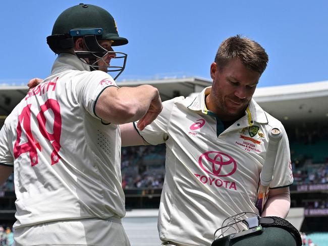 Australiaâs Steve Smith (L) hugs teammate David Warner who walks out after dismissal for the last time in his 112th and farewell Test on day four of the third cricket Test match between Australia and Pakistan at the Sydney Cricket Ground in Sydney on January 6, 2024. (Photo by Saeed KHAN / AFP) / -- IMAGE RESTRICTED TO EDITORIAL USE - STRICTLY NO COMMERCIAL USE --