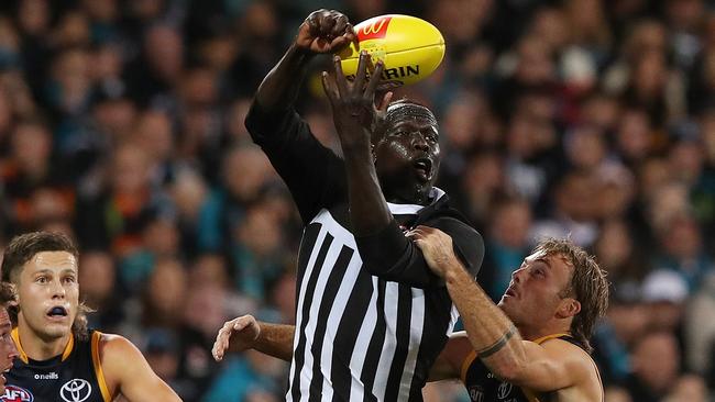 Aliir Aliir gets a handball away under pressure from Luke Pedlar. Picture: Sarah Reed/AFL Photos via Getty Images