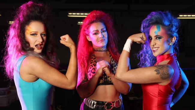 Pro wrestlers Avary, Kellyanne, and Erika Reid borrow some 80s inspiration from the show GLOW, with hair and make-up by Kerrie Stanley and Lexi Leigh and costumes from Rose Chong Costumes. Picture: Alex Coppel