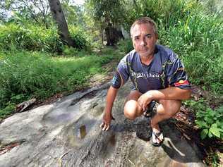 'OUR LAND': Kabi land rights claimant Wit-boooka shows hollows in the surface rock of the ridge, which he says his people used to grind seeds. Picture: Patrick Woods