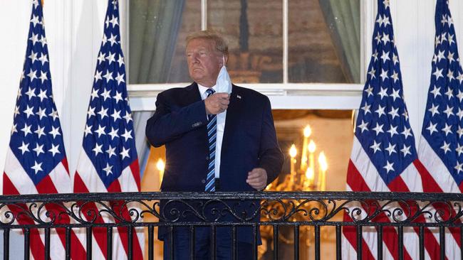 Donald Trump removes his mask upon return to the White House. Picture: AFP