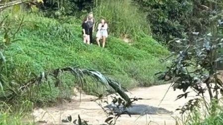 Three young women, believed to be to be tourists, get close and personal with a 4m saltwater crocodile, known by Babinda residents as Clyde.