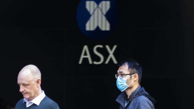 SYDNEY, AUSTRALIA - MARCH 13: A man in a mask is seen in front of The Australian Stock Exchange logo on March 13, 2020 in Sydney, Australia. The ASX200 plunged more than 7 percent in the first 15 minutes of trade on Friday, amid fears over the spread of COVID-19. The Australian sharemarket fall follows the worst day of trading on Thursday, which saw the worst losses since the Global Financial Crisis. (Photo by Jenny Evans/Getty Images)