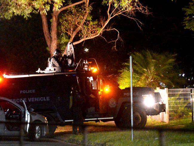 Heavily armed police approach a home last night hunting for the killer of a man in Heckenberg in Sydney's southwest. Photo Jeremy Piper