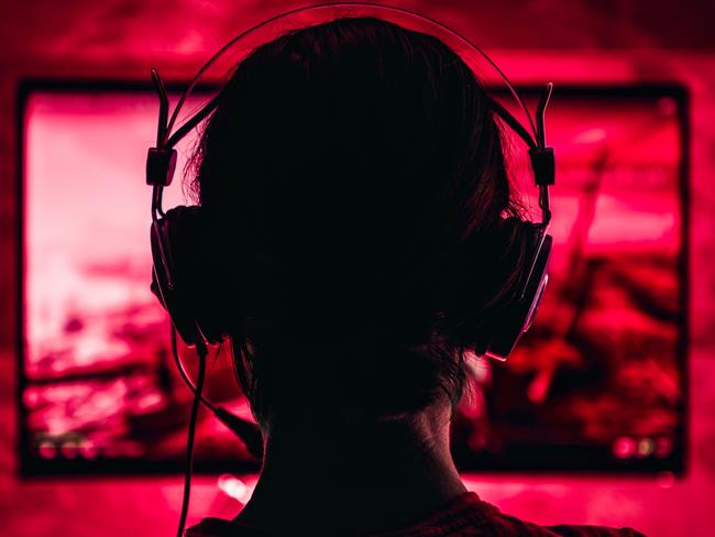 Woman wearing headphones playing video games late at night Picture: Istock