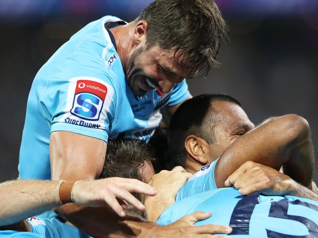 SYDNEY, AUSTRALIA - MARCH 23: Jake Gordon of the Waratahs jumps on his team to congratulate Israel Folau of the Waratahs as he celebrates scoring a try during the round six Super Rugby match between the Waratahs and the Crusaders on March 23, 2019 in Sydney, Australia. (Photo by Mark Kolbe/Getty Images)