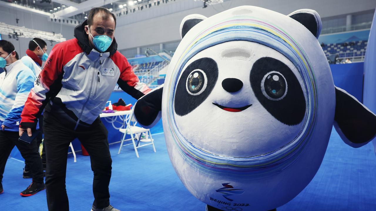 A staff member poses with a Beijing Winter Olympics mascot Bing Dwen Dwen.