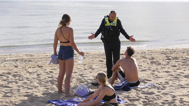 Police enforcing the closure of St Kilda beach in March. There are concerns sunny weather this weekend may attract people back to the water. Picture: Wayne Taylor