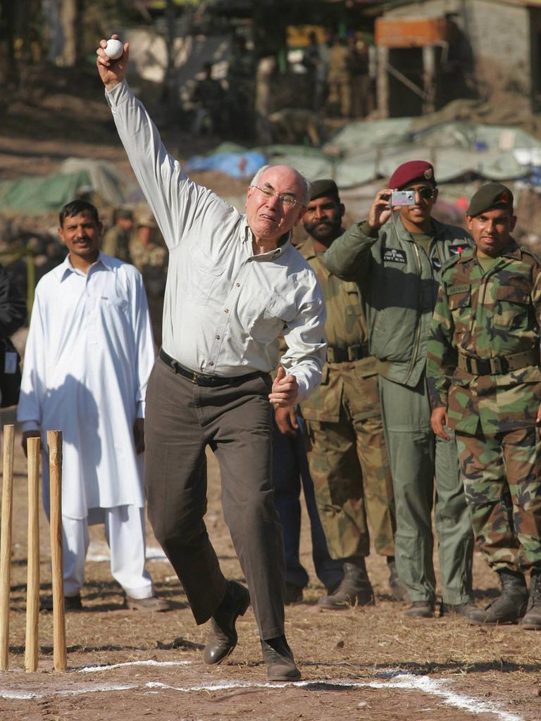 Former Prime Minister John Howard takes on a young Pakistan batsman in a game of cricket at Dhanni in 2005.