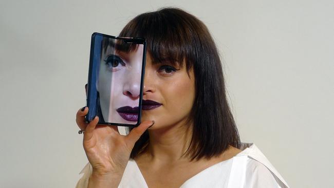 A model holds a Samsung Galaxy Fold smartphone to her face, during a media preview event in London. Picture: AP 