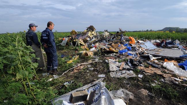 Employees of the Ukrainian State Emergency Service look at the wreckage of Malaysia Airlines flight MH17 two days after it crashed in a sunflower field near the village of Rassipnoe, in rebel-held east Ukraine. Picture: AFP