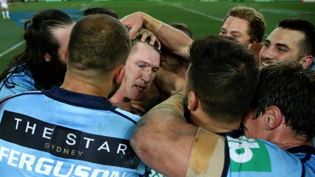 Paul Gallen is mobbed by teammates after winning the series finale in 2016.