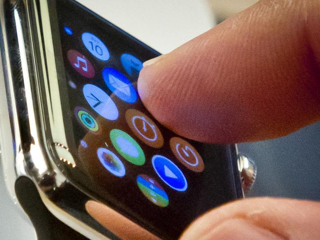 FILE - In this April 10, 2015 file photo, a customer examines Apple's new watch in New York. The first batch of Apple Watches will arrive in people’s homes and offices Friday April 24, 2015. (AP Photo/Bebeto Matthews)