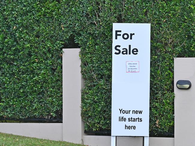 Real estate for sale sign in front of a house