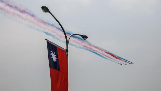 Taiwan Air Force fighter jets perform manoeuvres as a Taiwanese flag hangs from a lamppost in Taipei. Picture: Bloomberg