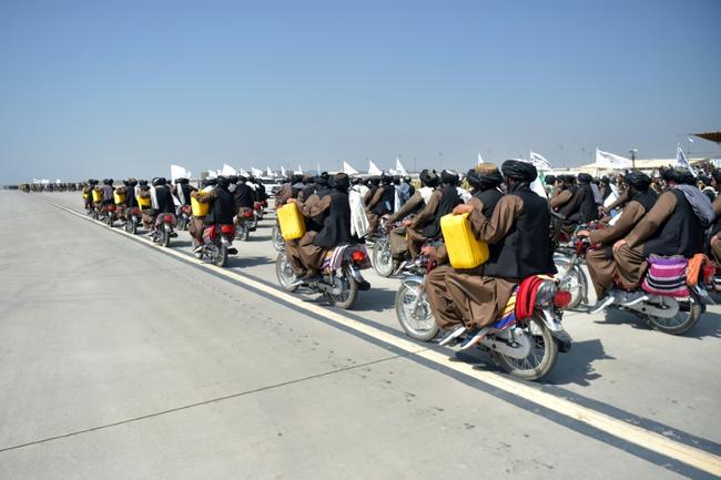 Taliban personnel carrying dummy yellow canisters, once used to carry homemade bombs, take part in a military parade at Bagram Air Base to mark the third anniversary of the takeover of Afghanistan