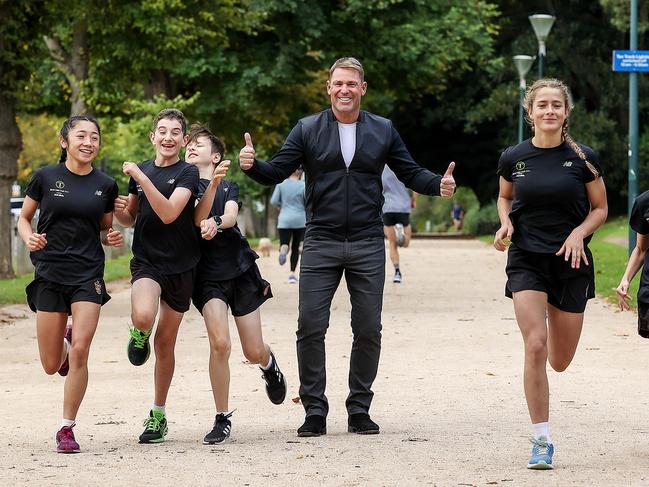 Shane Warne promotes the Run The Tan fun run with Haileybury College students. Picture: Ian Currie