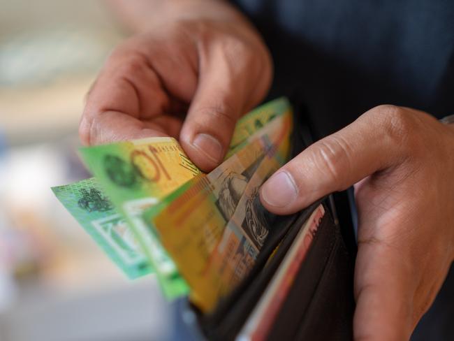 a male taking money out of a wallet, Australian cash generic spending