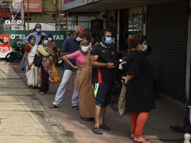 Indians wearing masks as a precaution against the coronavirus line up outside a government ration shop in Kochi, Kerala state, India. Picture: AP