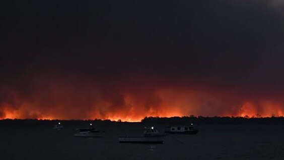 A haunting photo taken at sunset from the Burrum Heads boat ramp of the fire impacting Woodgate and Buxton. Picture: Madelyn Rivera