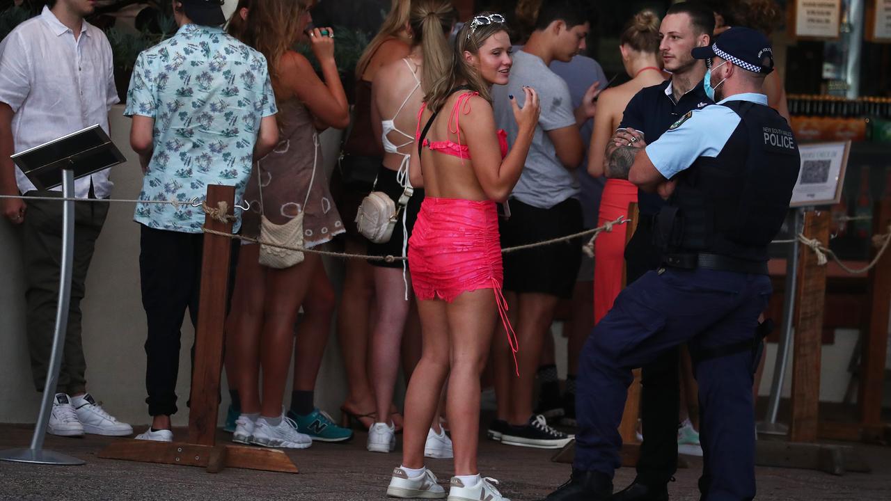 A young lady talks with police outside the Beach Hotel in Byron Bay. Picture: Jason O'Brien