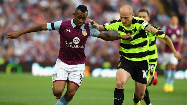 Jordan Ayew of Aston Villa holds off Aaron Mooy.