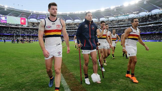 Luke Brown limps off the field on crutches after the Crows’ loss to Fremantle on Sunday. Picture: Will Russell/AFL Media/Getty Images