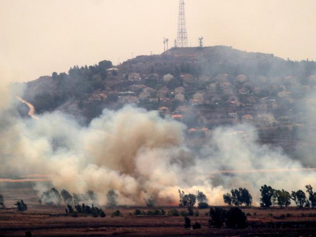 Smoke rises in the southern Lebanese Marjayoun plain after being hit by Israeli shelling on September 6, 2024, amid the ongoing cross-border clashes between Israeli troops and Hezbollah fighters. The Israeli northern town of Metulla can be seen in the background. (Photo by RABIH DAHER / AFP)