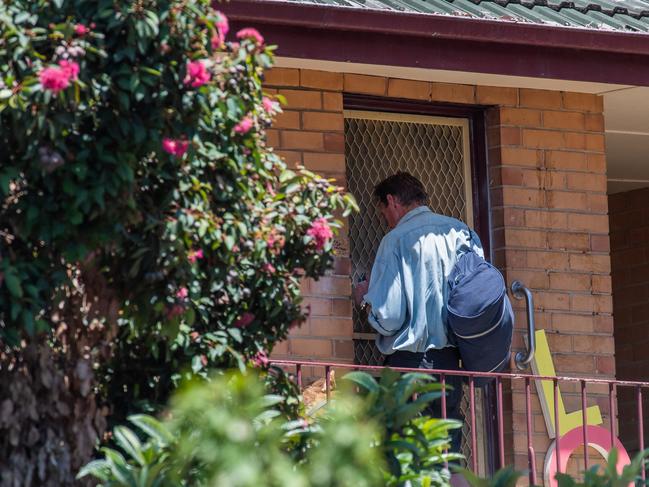 A man waits near the cut-out hole in the screen door last month. Picture: Jason Edwards