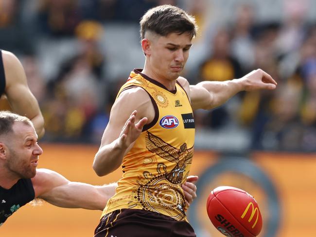 MELBOURNE - July 2  : AFL.   Sam Butler of the Hawks kicks at goal whilst being tackled by Sam Docherty of the Blues during the round 16 AFL match between Hawthorn and Carlton at the MCG on July 1, 2023.  Photo by Michael Klein.