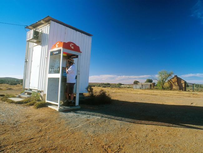 A customer uses the lone Telstra phone booth at Silverton a small outback town near Broken Hill on the New South Wales and South Australian borders, Tuesday October 22. 2002. Photographer; Gillianne Tedder/Bloomberg News