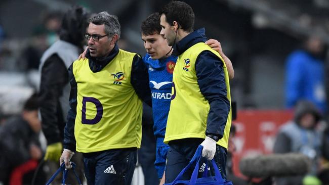 France's Antoine Dupont is led off the field after being injured during the Six Nations rugby union match between France and Ireland at the Stade de France in Paris on February 3, 2018. / AFP PHOTO / CHRISTOPHE SIMON