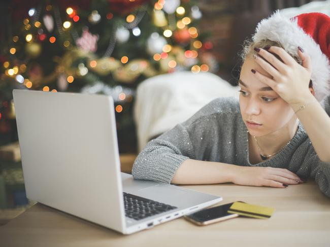 young woman in christmas interior with laptop; Christmas spending debt money generic