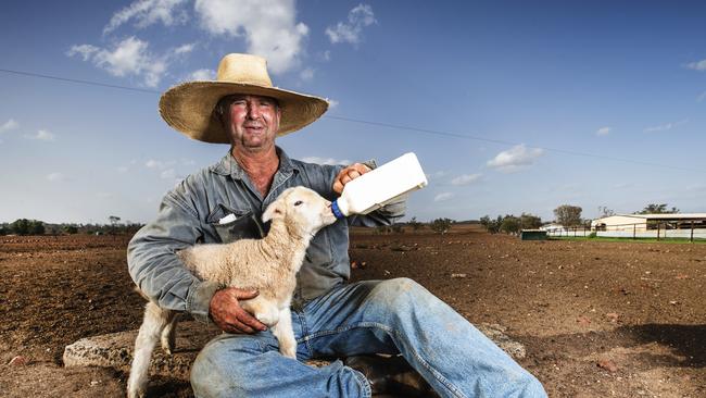 Western Queensland Grazier Will Roberts bottle feeding one of his poddy lambs on his drought hit property north east of Charleville. Picture: Lachie Millard