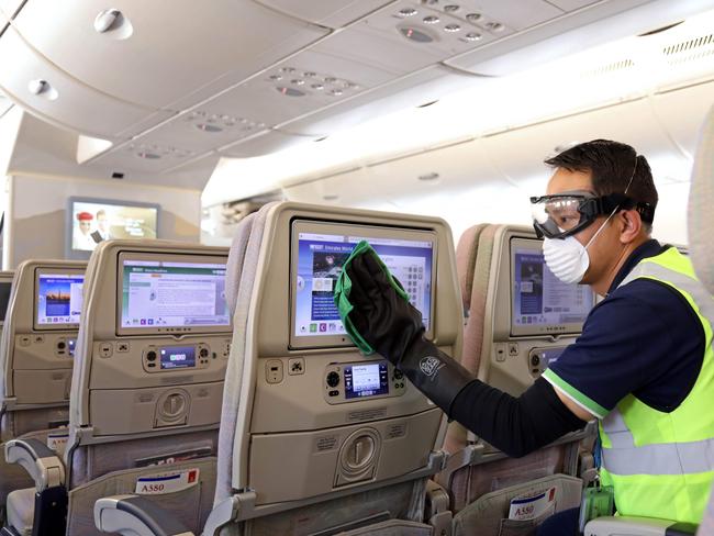 A member of Emirates cleaning staff disinfecting seat screens aboard an Emirates Airbus A380-800 aircraft amid efforts against COVID-19. Picture: AFP Photo