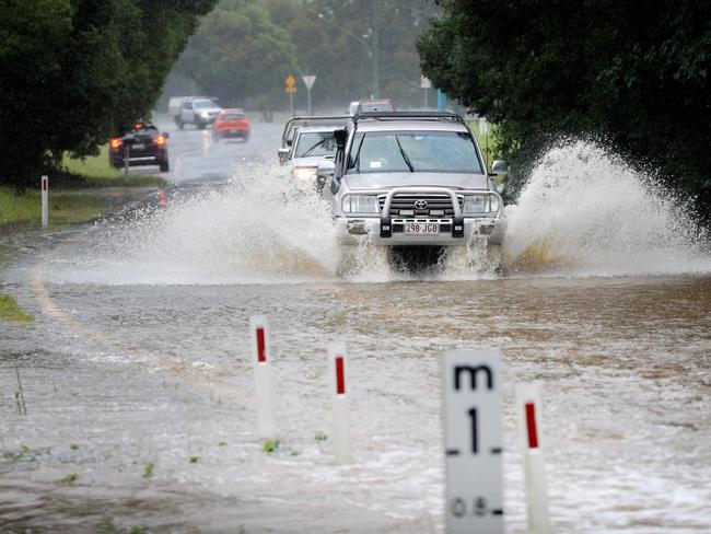 Drivers ignore rising flood water across Tallebudgera Connection Road, Tallebudgera, at the back of Currumbin Creek after torrential rain over night caused the creek to break its banks. NCA NewsWire / Scott Powick