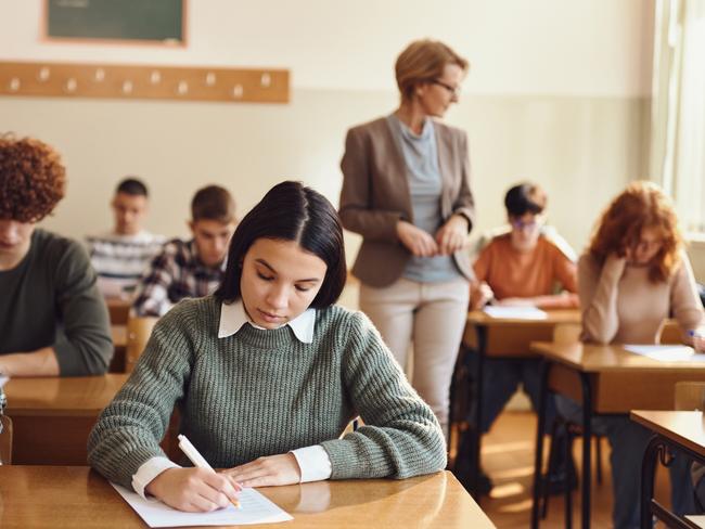 Schools of excellence - Large group of students having an exam during a class at high school.