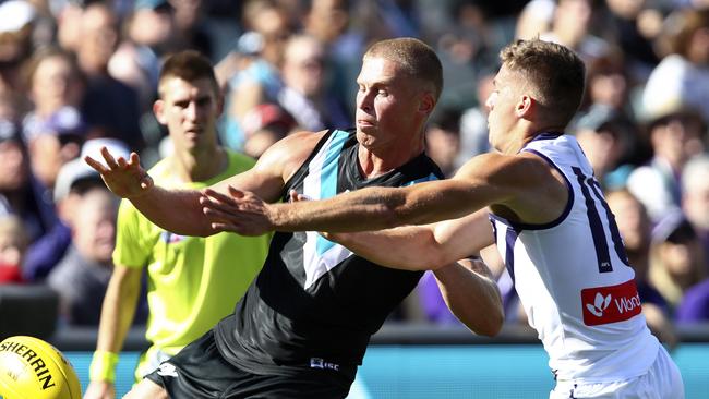 Tom Clurey gets a kick away under pressure from Fremantle’s Darcy Tucker. Picture Sarah Reed