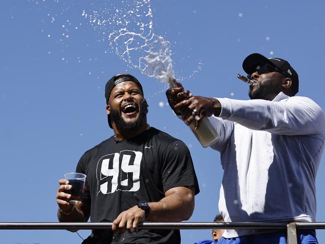 LOS ANGELES, CALIFORNIA - FEBRUARY 16: Aaron Donald #99 of the Los Angeles Rams (L) celebrates with champagne during the Super Bowl LVI Victory Parade on February 16, 2022 in Los Angeles, California.   Michael Owens/Getty Images/AFP == FOR NEWSPAPERS, INTERNET, TELCOS & TELEVISION USE ONLY ==