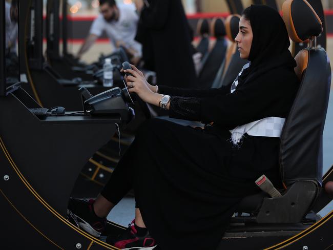 A young woman wearing tries out a driving simulator at an outdoor educational driving event for women on June 23, 2018 in Jeddah, Saudi Arabia. Picture: Getty